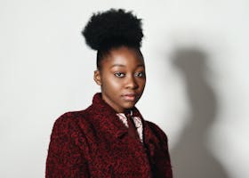 Elegant portrait of a young woman with afro hairstyle in a fashionable red coat.